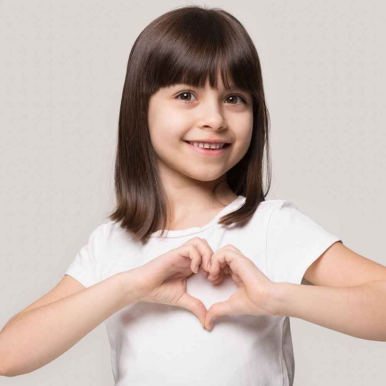 Girl making heart gesture with her hands.