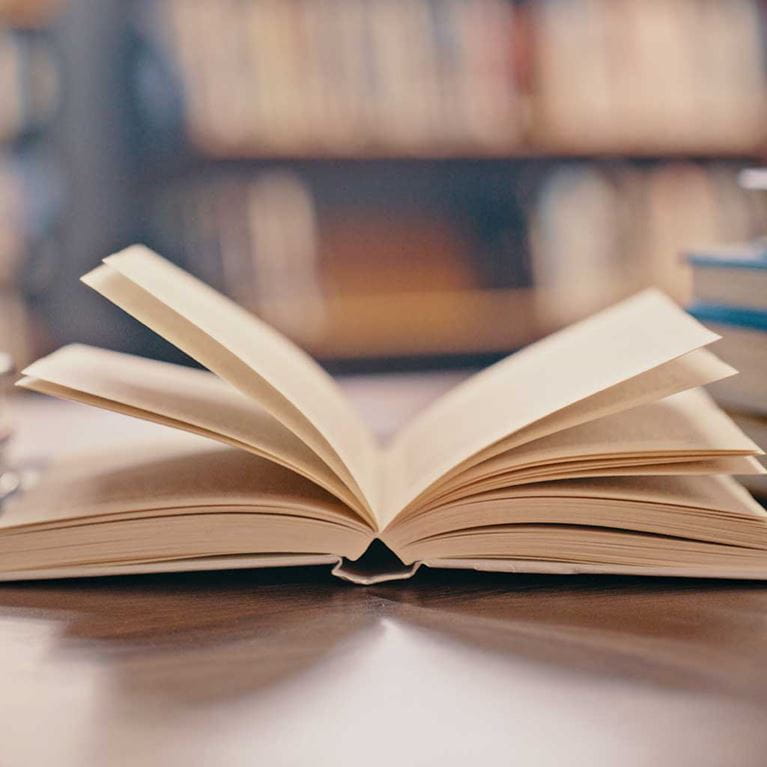 Open book on library table.