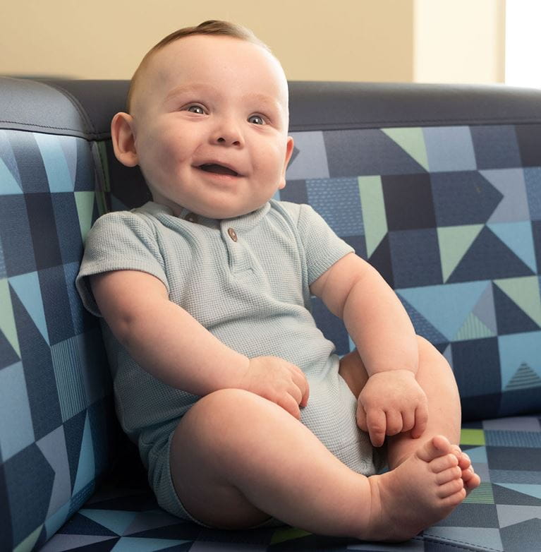 Boy in blue onesie with red hair.