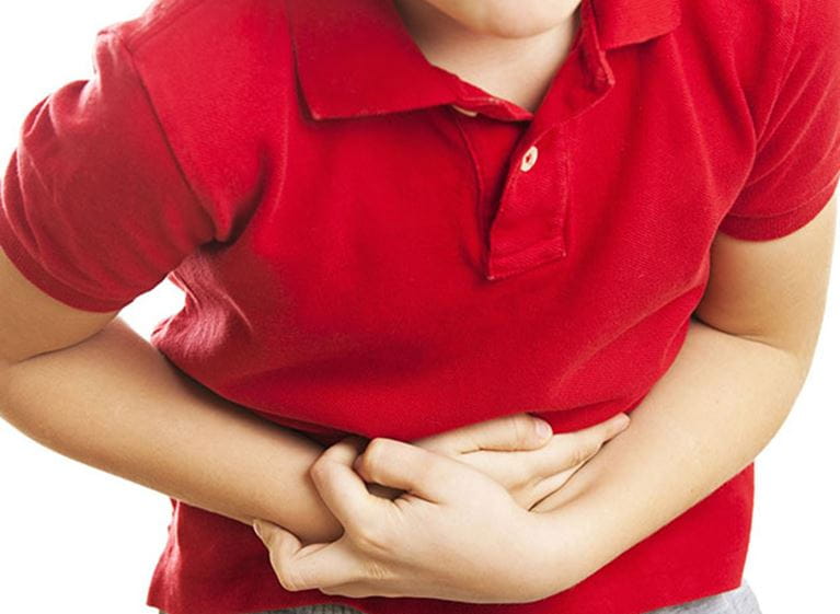 Child in red shirt gripping tummy